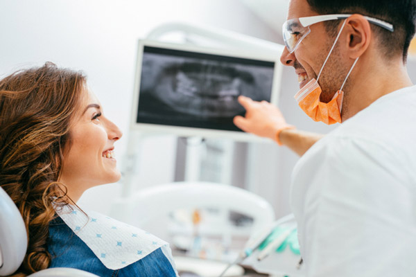 Dentist explaining an xray to a woman patient at Picasso Dental Care in Temecula, CA 