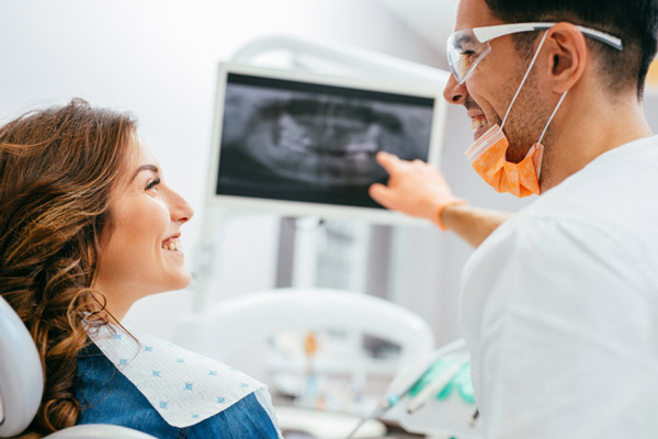 Dentist explaining an xray to a woman patient before a gum grafting procedure at Picasso Dental Care in Temecula, CA 