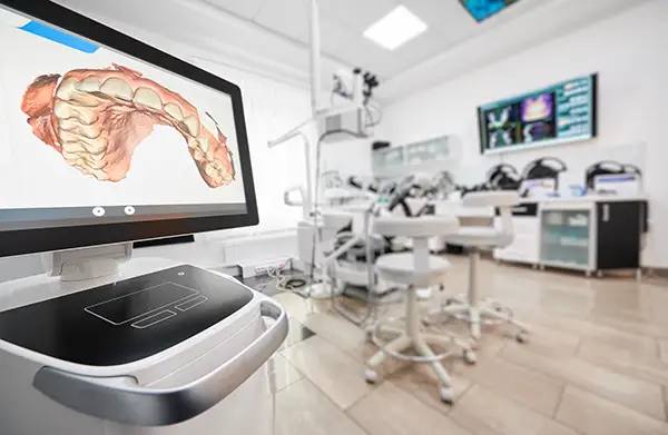 A 3D dental model displayed on a monitor in a high-tech dental office equipped with advanced digital tools.