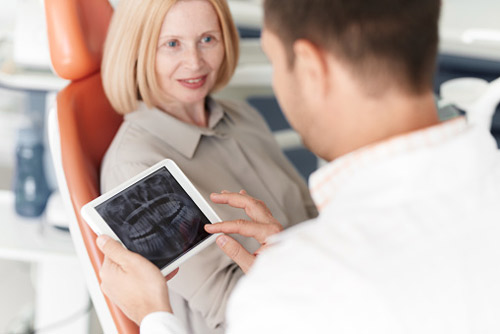 Older woman discussing dental implants with her dentist at Picasso Dental Care in Temecula, CA